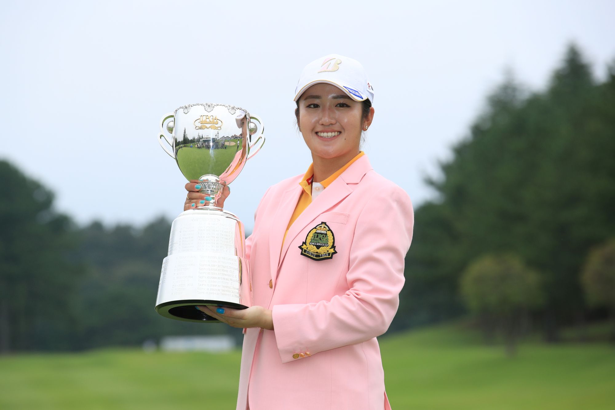 Mone Inami dengan trofi JLPGA Championship Konica Minolta Cup.
